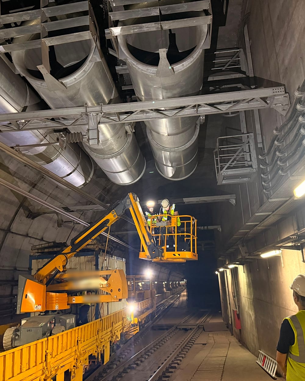 Metro tünelinde platformlu iş makinesiyle tavan tesisatı üzerinde çalışan ekibimiz